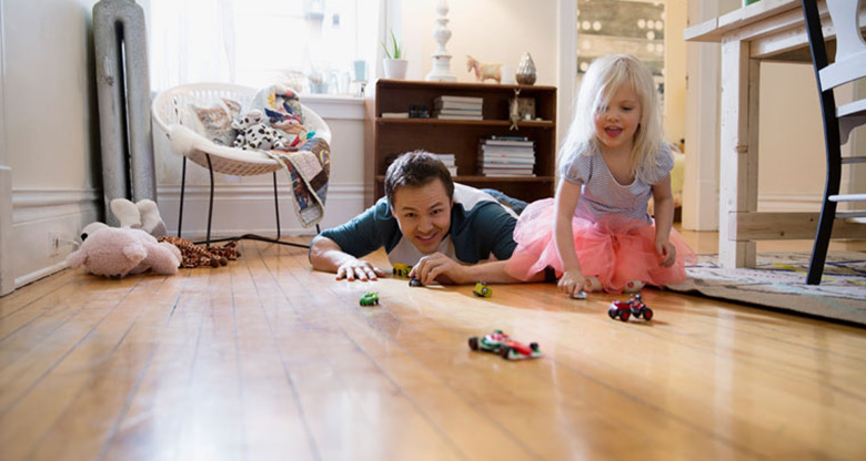 father and daughter playing with toy cars